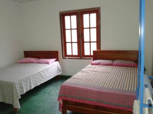 1 Schlafzimmer mit 2 Betten und einem Fenster in der Unterkunft Horton Mountain in Ohiya