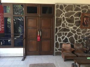 eine Lobby mit einer Holztür und einer Steinmauer in der Unterkunft Rumah Saga in Gili Trawangan