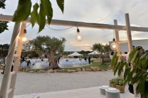 una boda al aire libre con luces y una mesa con platos en Masseria Corte Masseriola, en Alberobello