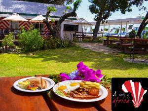 a table with two plates of breakfast food on it at Addo River-View Lodge in Colchester