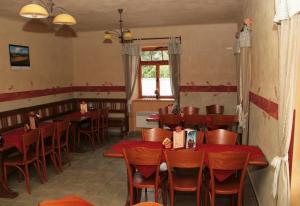 un restaurant avec des tables et des chaises rouges et une fenêtre dans l'établissement Penzion Haberský vrch, à Habří