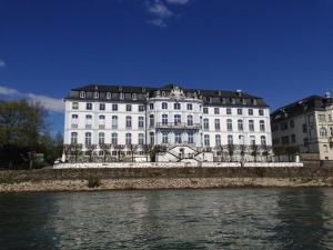 Hotel zur Schloß-Schenke في نيوفيد: مبنى ابيض كبير بجانب تجمع المياه