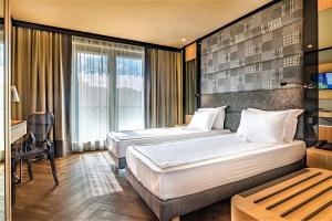 a hotel room with two beds and a desk at Eurostars Sofia City in Sofia