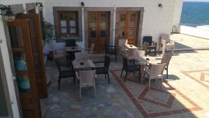 un restaurante con mesas y sillas en un patio en Armyra Hotel en Skala