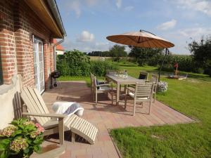 a patio with a table and chairs and an umbrella at Marina Chic in Hasselberg