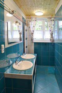 a bathroom with two sinks and blue tiles at Chata Sýkorka in Rejvíz
