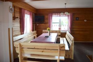 a dining room with a table and two benches at Chata Sýkorka in Rejvíz