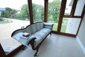 クリフデンにあるIsland View Luxury Apartmentの大きな窓のある客室で、ソファが備わります。