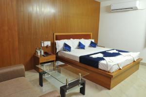 a bedroom with a bed and a glass table at New Hotel Shiva in Bodh Gaya +16 photos