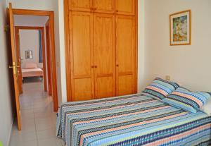 エル・メダノにあるAlquilaencanarias-Medano Galte, terrace and beachのベッドルーム1室(ストライプ毛布付きのベッド1台付)