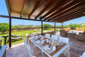 - un coin repas extérieur avec une table et des chaises dans l'établissement MarySol Luxury Villa, à Gennadi