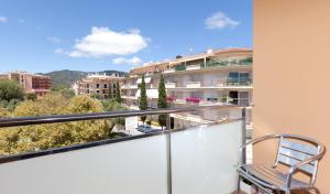 a chair on a balcony with a view of a building at Hotel Turissa in Tossa de Mar