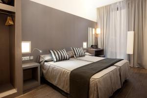 a hotel room with a bed and two lamps at Dalia Ramblas in Barcelona