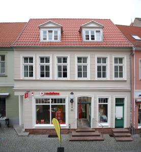 een groot wit gebouw met een rood dak bij Appartements am Markt in Greifswald