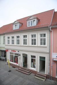 ein großes weißes Gebäude mit rotem Dach in der Unterkunft Appartements am Markt in Greifswald