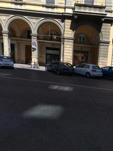 eine Gruppe von Autos, die vor einem Gebäude geparkt sind in der Unterkunft Miro' Holiday Attic in Bologna