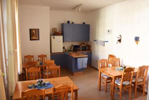 a dining room with wooden tables and a kitchen at Pension zur Wartburg in Görlitz