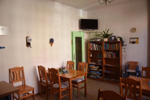 a dining room with a table and chairs and a book shelf at Pension zur Wartburg in Görlitz