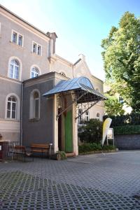 un edificio con una puerta verde en un patio de ladrillo en Pension zur Wartburg, en Görlitz