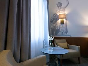 Zimmer mit einem Tisch, Stühlen und einem Fenster in der Unterkunft Platzl Hotel - Superior in München