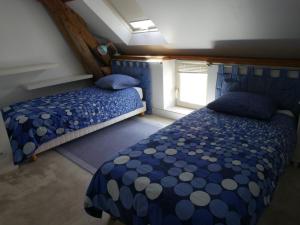 a bedroom with two beds and a window at Gîtes de la Grande Ferme in Avernes