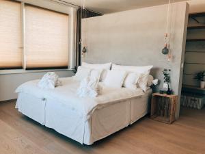 Schlafzimmer mit einem Bett mit weißer Bettwäsche und Kissen in der Unterkunft AVLiving City LOFT Basel in Basel