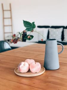 drei rosa Donuts auf einem Teller neben einer Vase in der Unterkunft AVLiving City LOFT Basel in Basel