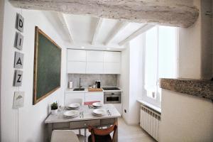 una pequeña cocina con mesa y pizarra verde en CasaDiaz 11, en Como 25 fotos más