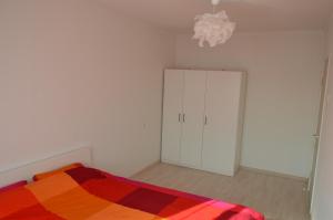 a bedroom with a bed and a cabinet and a chandelier at Apartment with Sea View in Liepāja