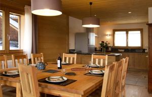 uma cozinha e sala de jantar com uma mesa de madeira e cadeiras em Odalys Chalet Levanna Orientale em Les Deux Alpes