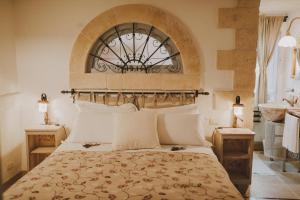 um quarto com uma cama grande e uma janela em Masseria Montenapoleone em Fasano