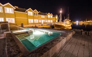 uma piscina com um barco na água em Siglo Hotel by Keahotels em Siglufjörður