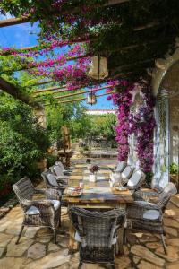 a patio area with tables, chairs, and umbrellas at Masseria Montenapoleone in Pezze di Greco