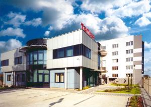 a white building with a red sign on it at Gosciniec Tombor in Katowice