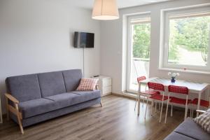 a living room with a couch and a table at Apartamenty Kamienna z widokiem na góry i 2 km do Wyciągu Skolnity - Dream Apart in Wisła