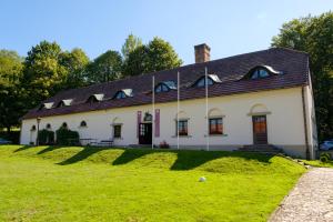 Biały dom z czarnym dachem na zielonym polu w obiekcie Dwor Rychwald w mieście Rychwałd