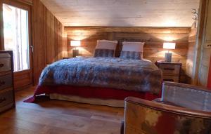 - une chambre avec un lit et un mur en bois dans l'établissement Odalys Chalet Les Alpages, à Les Deux Alpes
