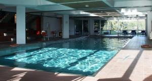 duży basen z niebieską wodą w budynku w obiekcie TH 1400 Hotel w mieście Marilleva