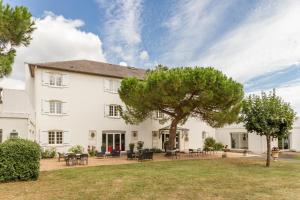 a large white house with a tree in the yard at Logis Hôtel Restaurant des Châteaux in Azay-le-Rideau