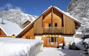 a log cabin in the mountains with snow on the ground at Odalys Chalet Le Pleynet in Vénosc
