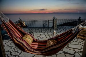 een hangmat op een patio met uitzicht op de oceaan bij Ionian Sensations - Villa Anastasia in Kalamitsi