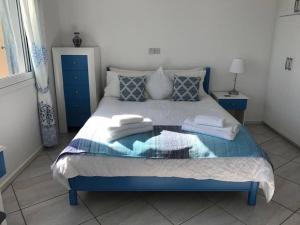 a blue and white bed with two towels on it at Modern penthouse with incredible sea views in Paphos City