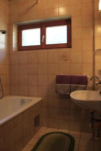 a bathroom with a bath tub and a sink at Haus Weber Pressegger See in Hermagor