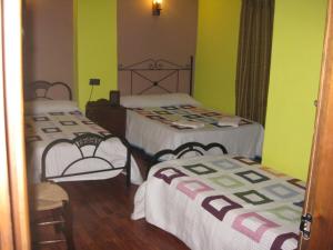 2 Betten in einem Zimmer mit grünen Wänden in der Unterkunft El Encinar de Cobo in Fuensanta de Martos