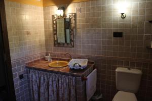 Un baño con lavabo, inodoro y espejo. en El Encinar de Cobo, en Fuensanta de Martos 16 fotos más