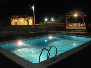 una piscina por la noche con cenador en El Encinar de Cobo, en Fuensanta de Martos
