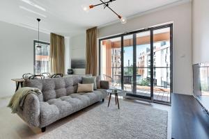 a living room with a couch and a large window at Blue Mandarin Riverside in Gdańsk