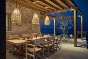 a dining room with a table and chairs and the ocean at Niova Villa in Alykes