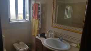 a bathroom with a sink and a mirror at Villa da Praia Azul in Silveira +23 photos
