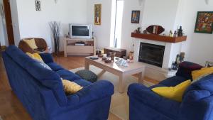 a living room with two blue chairs and a table at Villa da Praia Azul in Silveira